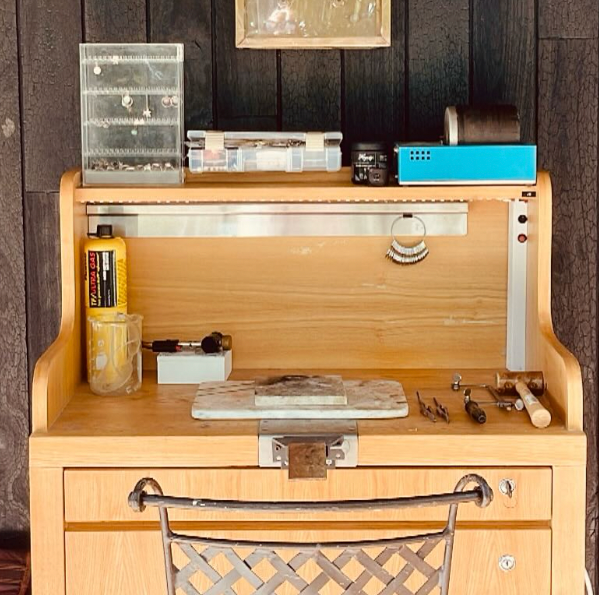 Wooden desk with various items against a wooden wall.